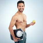 Fitness, portrait or man with an apple or scale in studio for motivation to lose weight on a healthy diet. Fruit, nutrition or male model with body goals, training target or happy smile with mockup