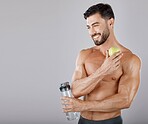 Man, water bottle and apple for healthy lifestyle, diet and wellness in grey studio background. Male, guy and bodybuilder with fruit, hydration and healthcare for fitness, nutrition and motivation