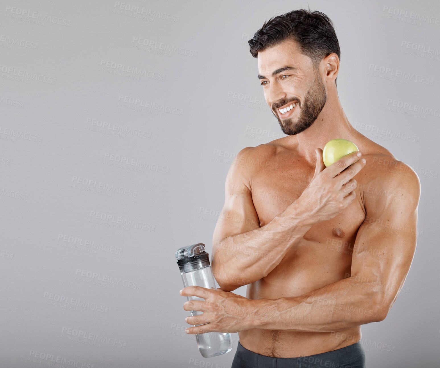 Buy stock photo Man, water bottle and apple for healthy lifestyle, diet and wellness in grey studio background. Male, guy and bodybuilder with fruit, hydration and healthcare for fitness, nutrition and motivation