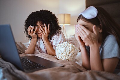 Buy stock photo Women, horror or laptop movie in house bedroom on subscription channel, popcorn entertainment or streaming app. Scared, friends or hand on face on bed, scary technology cinema or relax home bonding