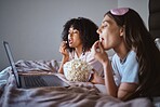 Laptop, movie and relax with friends and popcorn in bedroom for sleepover, bonding and streaming. Technology, internet and online with women at night for cinema, subscription and film entertainment