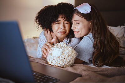 Buy stock photo Laptop, movie and horror with friends and popcorn in bedroom for sleepover, bonding and streaming. Technology, internet and relax with scared women at night for cinema, subscription and entertainment