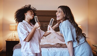 Buy stock photo Friends, singing with brush and women in bedroom to get ready for girls night out dancing, fun music concert and happiness. Girl, friend and happy smile, girlfriends grooming at sleepover in pajamas.