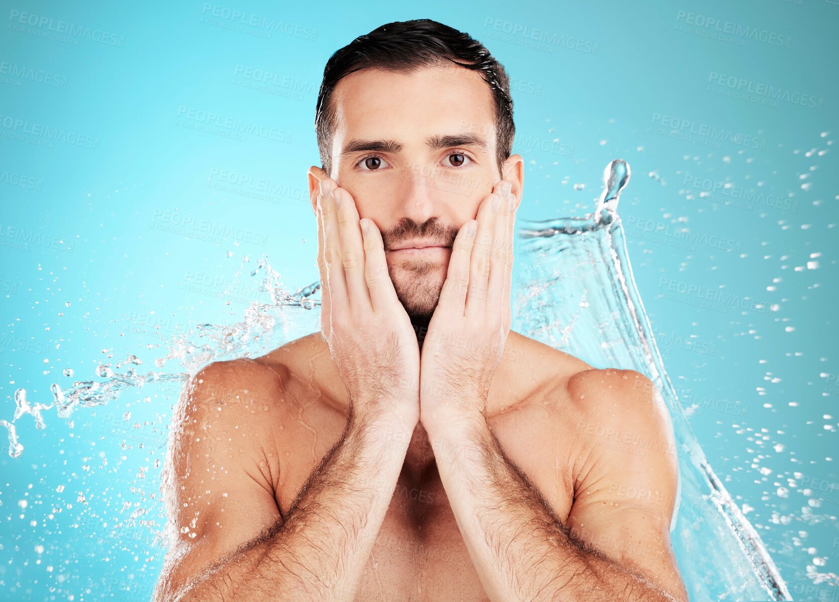 Buy stock photo Water splash, facial and portrait of man with skincare on face and morning detox routine isolated on blue background. Hygiene, male model hands and grooming for health, wellness and beauty in studio.