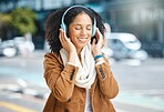 Music, headphones and black woman happy in city for travel, motivation and mindset. Young person on urban street with buildings background listening and streaming podcast or motivation audio outdoor