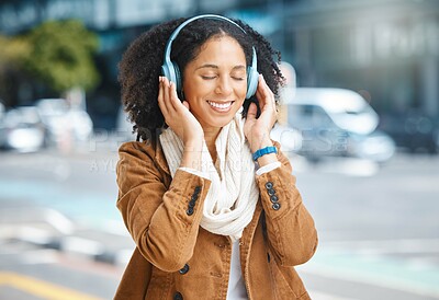 Buy stock photo Music, headphones and black woman happy in city for travel, motivation and mindset. Young person on urban street with buildings background listening and streaming podcast or inspiration audio outdoor