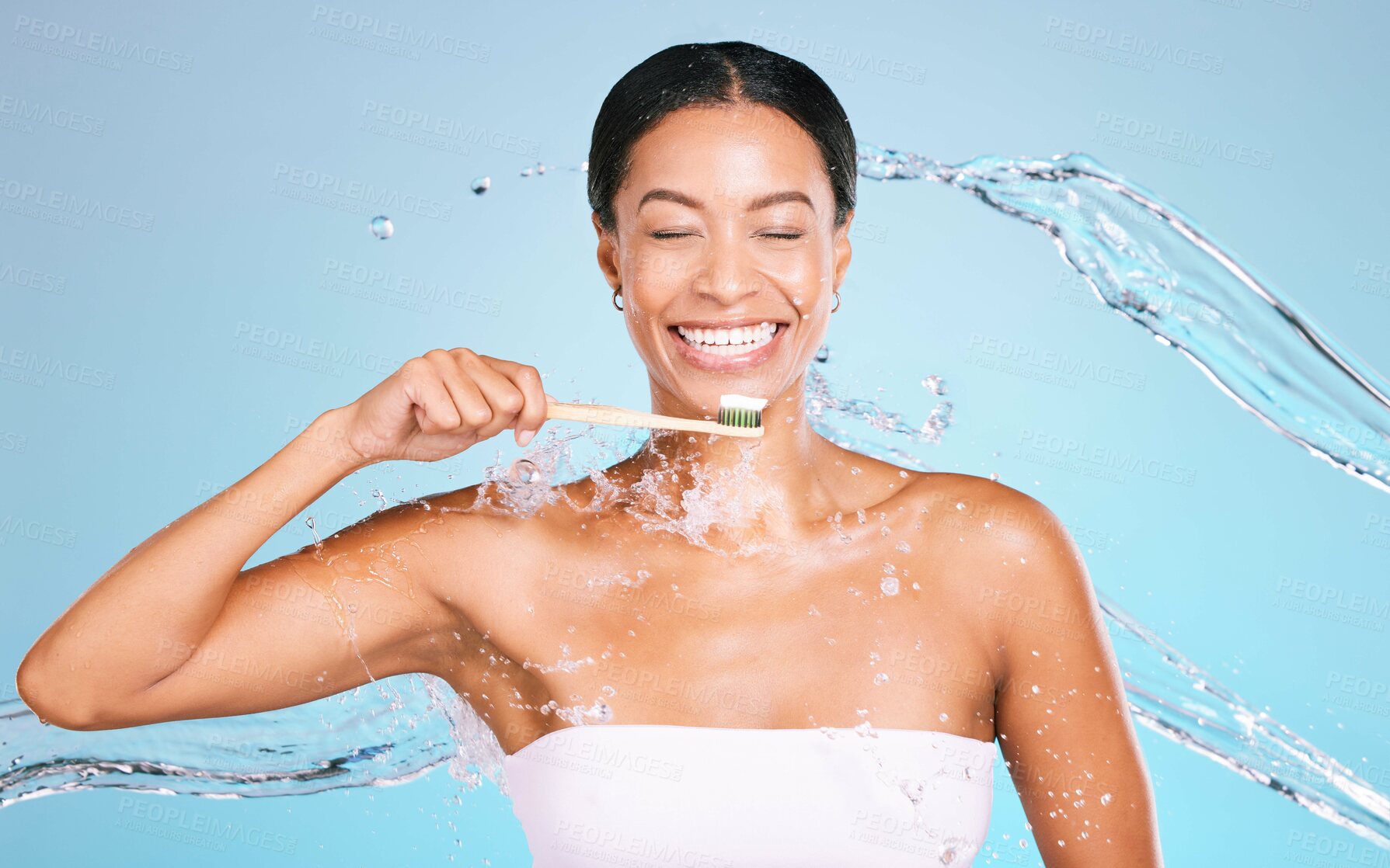 Buy stock photo Bamboo toothbrush of black woman isolated on blue background with toothpaste, water splash and dental health. Model or person brushing teeth with eco friendly and sustainable product in studio mockup