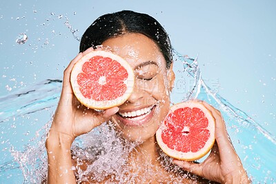 Buy stock photo Beauty, grapefruit and skin care with a woman for healthy skin and diet on a blue background. Face of aesthetic model person with water splash and fruit for sustainable facial health and wellness