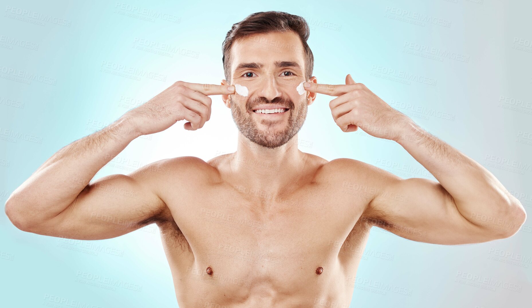 Buy stock photo Skincare, applying and portrait of a man with cream isolated on a blue background in studio. Glow, dermatology and model with lotion or sunscreen for cosmetic grooming and treatment on a backdrop