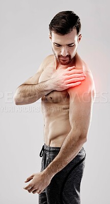 Injury, feeling and a man with arm pain and muscle sprain isolated on a grey studio background. Emergency, broken bone and person touching a painful, swollen and hurt area in the body on a backdrop