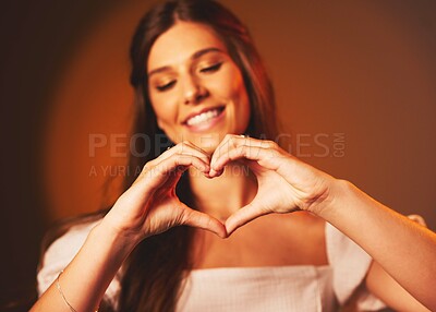 Buy stock photo Woman, hand heart sign and love symbol of a happy female person in studio. Smile, happiness and loving emoji hands gesture with brown background and gen z model ready for a valentines day date