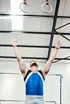 Man, gymnast and stance with hanging rings in fitness for practice, training or workout at gym. Professional male in gymnastics or acrobat looking up in athletics, acrobatics or strength exercise