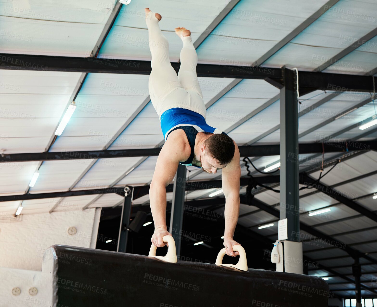 Buy stock photo Man, acrobat and gymnastics upside down in balance for fitness practice, training or workout at gym. Professional male gymnast holding up body weight in pommel horse, athletics or strength exercise