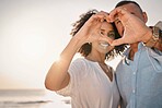 Love, couple and heart hands at beach on vacation, smile or having holiday fun. Ocean sunset, interracial romance and happy man and woman with affection emoji or gesture for care, trust or commitment