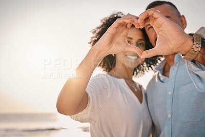 Buy stock photo Love, couple and heart hands at beach on vacation, smile or having holiday fun. Ocean sunset, interracial romance and happy man and woman with affection emoji or gesture for care, trust or commitment