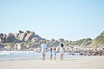 Travel, holding hands and family at the beach for walking, bonding and on vacation in summer. Care, nature and back of parents and children with affection while on a walk by the sea during a holiday