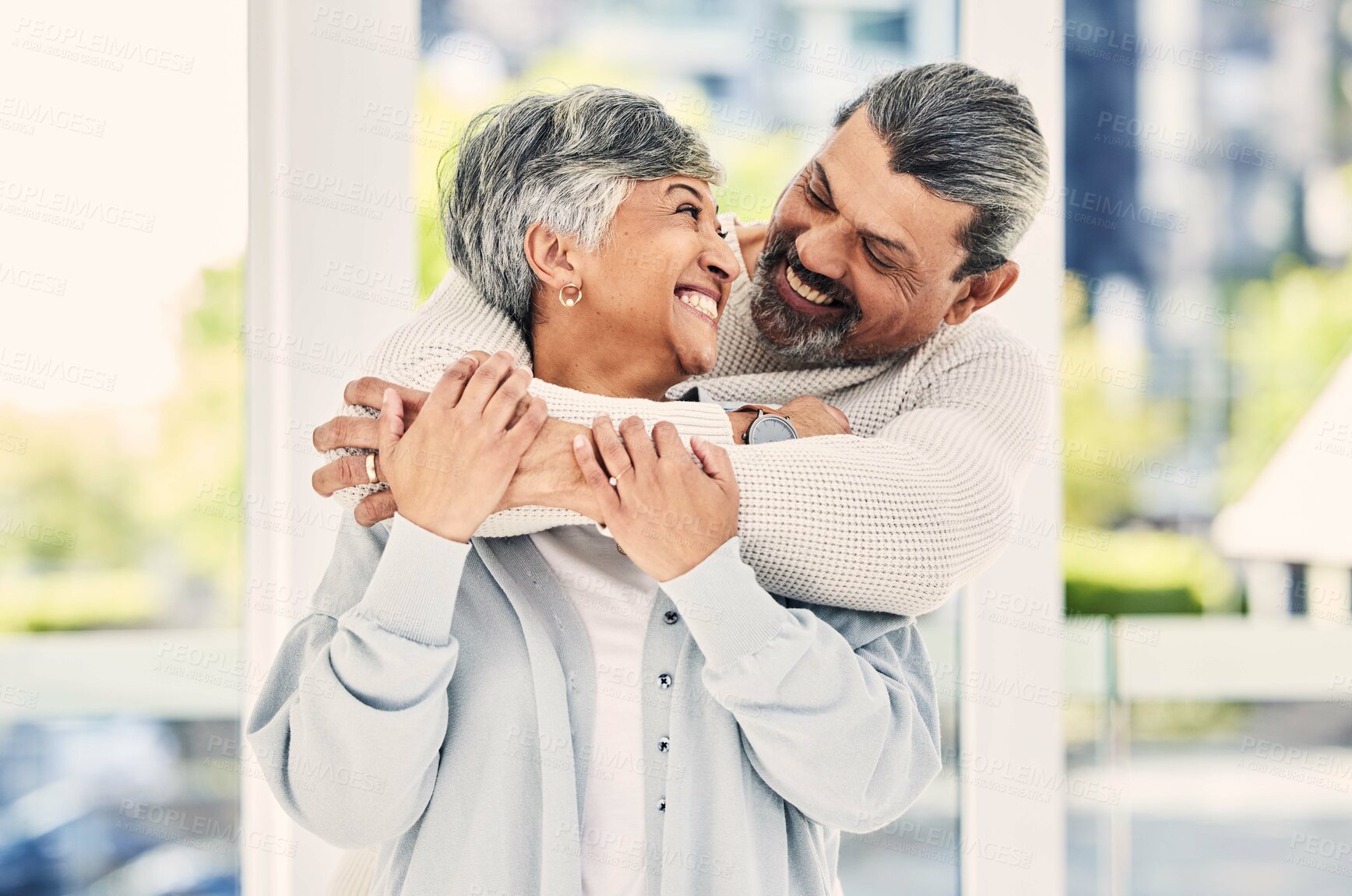 Buy stock photo Hug, marriage and senior couple with love, smile and retirement with happiness, home and bonding. Old woman, happy mature man and embrace in a lounge, loving together and romance with a relationship
