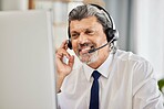 Happy, call centre and a man at a computer with a headset and a smile for customer service. Face of a mature male consultant or agent for technical support, help desk or crm advice and telemarketing