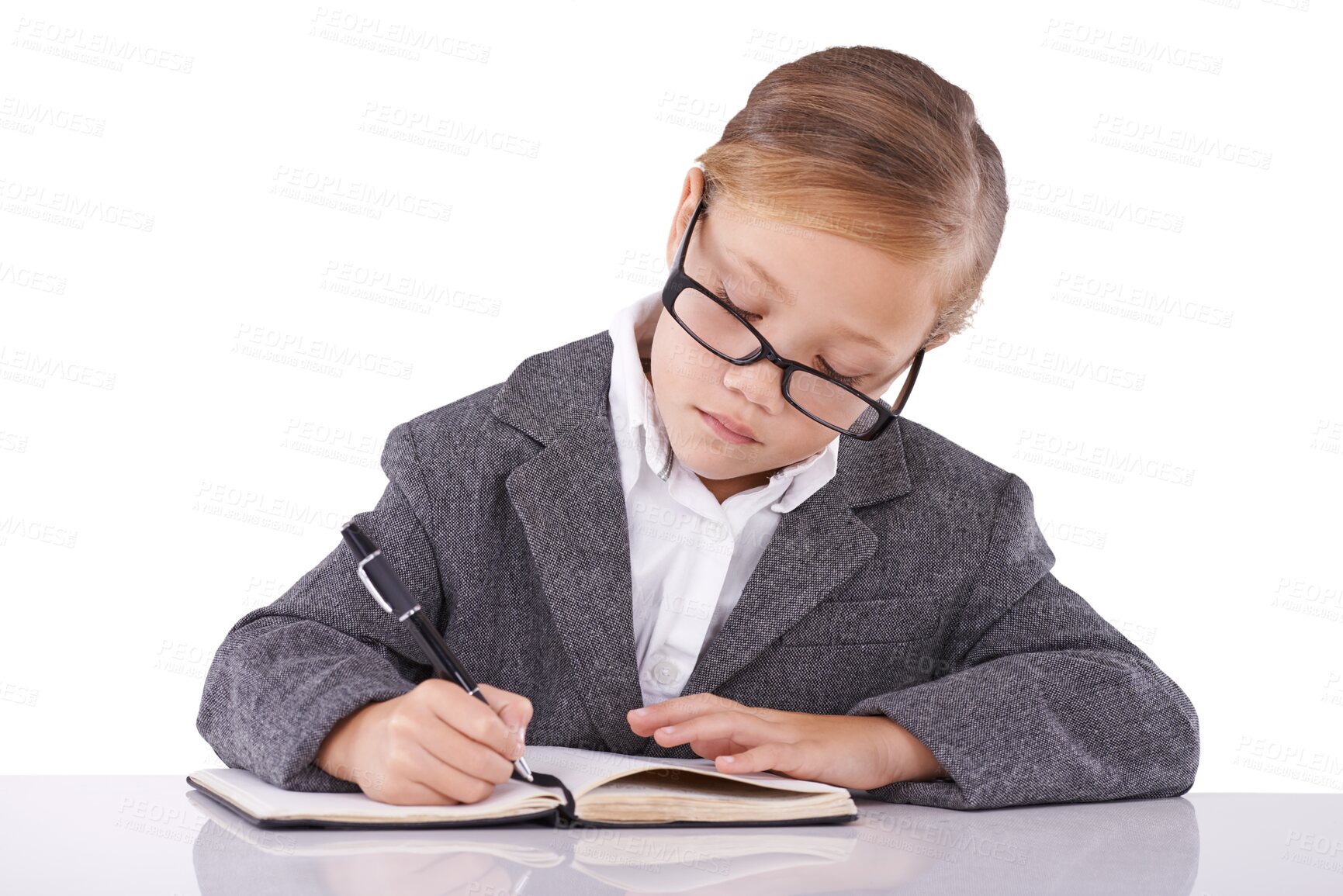 Buy stock photo Business kid in suit, writing at desk and book for learning, education and study. Girl, child and notebook at table, professional working and serious student isolated on a transparent png background