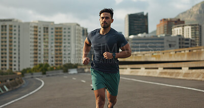 Buy stock photo Running, city and man on road in training, endurance and fitness lifestyle for marathon competition. Indian runner, exercise commitment and body wellness for cape town race, progress and urban sport