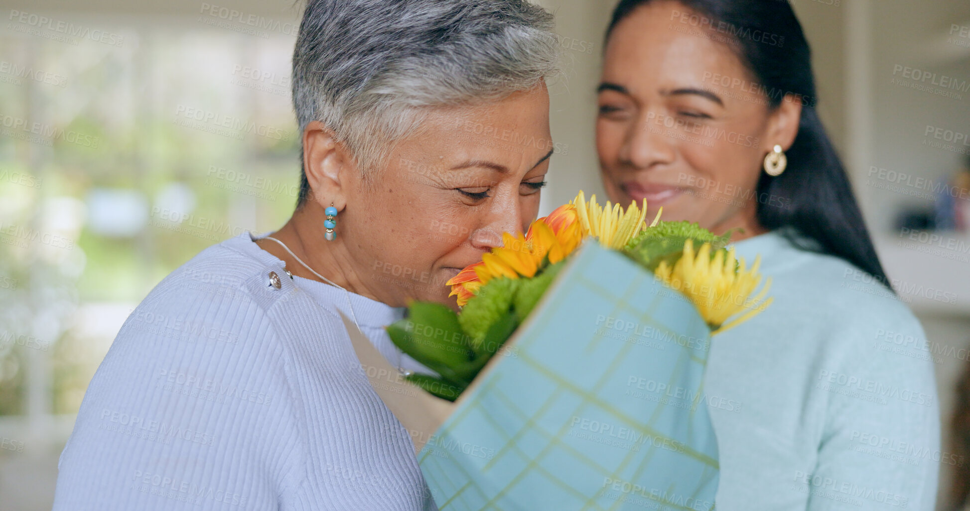 Buy stock photo Love, flowers and mother and daughter in home for bonding, relationship and celebrate together. Family, happy and mature mom embrace adult woman for mothers day, support and birthday in living room