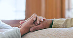 Comfort, support and senior couple holding hands in living room at modern home for romance and compassion. Love, empathy and closeup of elderly man and woman with affection in the lounge of a house.