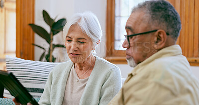 Buy stock photo Tablet, love and a senior couple on a sofa in the living room of their home to search social media together. Interracial, app or tech with an elderly man and woman in the apartment for retirement