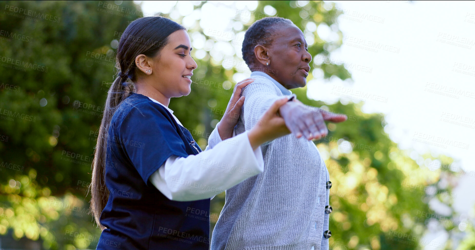 Buy stock photo Senior, woman and nurse with arm stretching for exercise, workout or fitness in a park with smile. People, professional or caregiver with activity for physiotherapy, wellness and health in nature