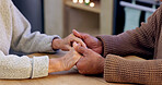 Couple, holding hands and closeup for praying in home with faith, religion and hope for peace at desk. People, prayer and together with support, empathy and care with worship for connection to God