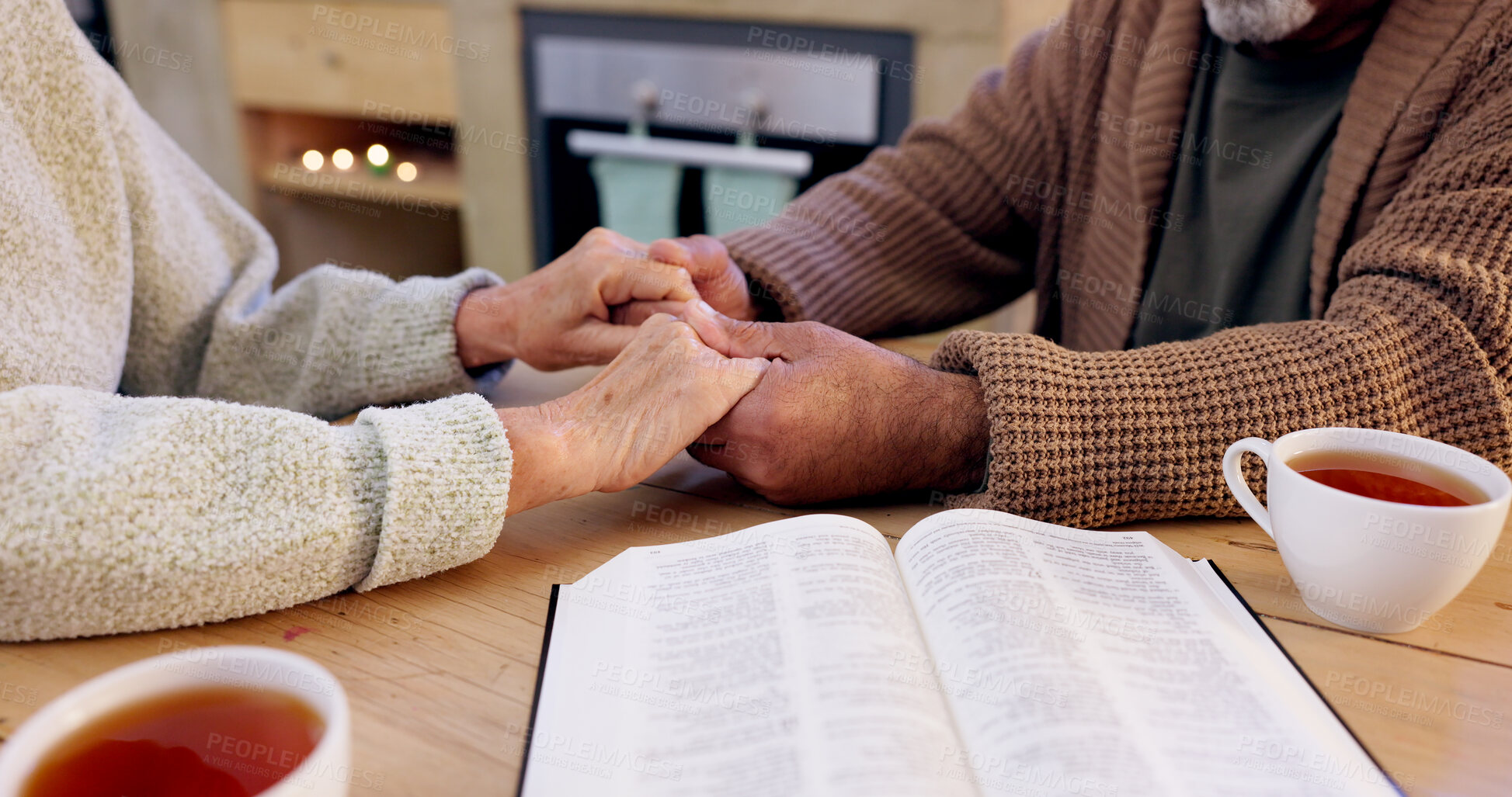 Buy stock photo Bible study, senior couple and holding hands for praying, religion and closeup in home for mindfulness. Elderly person, book and hope for peace, gratitude or connection to God, holy spirit or faith