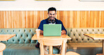 Happy man in cafe, typing on laptop and remote work, reading email or writing blog, article or search on tech. Computer, freelancer and editor in coffee shop, store or restaurant for project at table