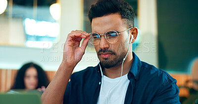 Man, reading glasses and cafe for online research, remote work and review of website design and analysis. Freelancer worker or designer in coffee shop or restaurant with computer for internet or info