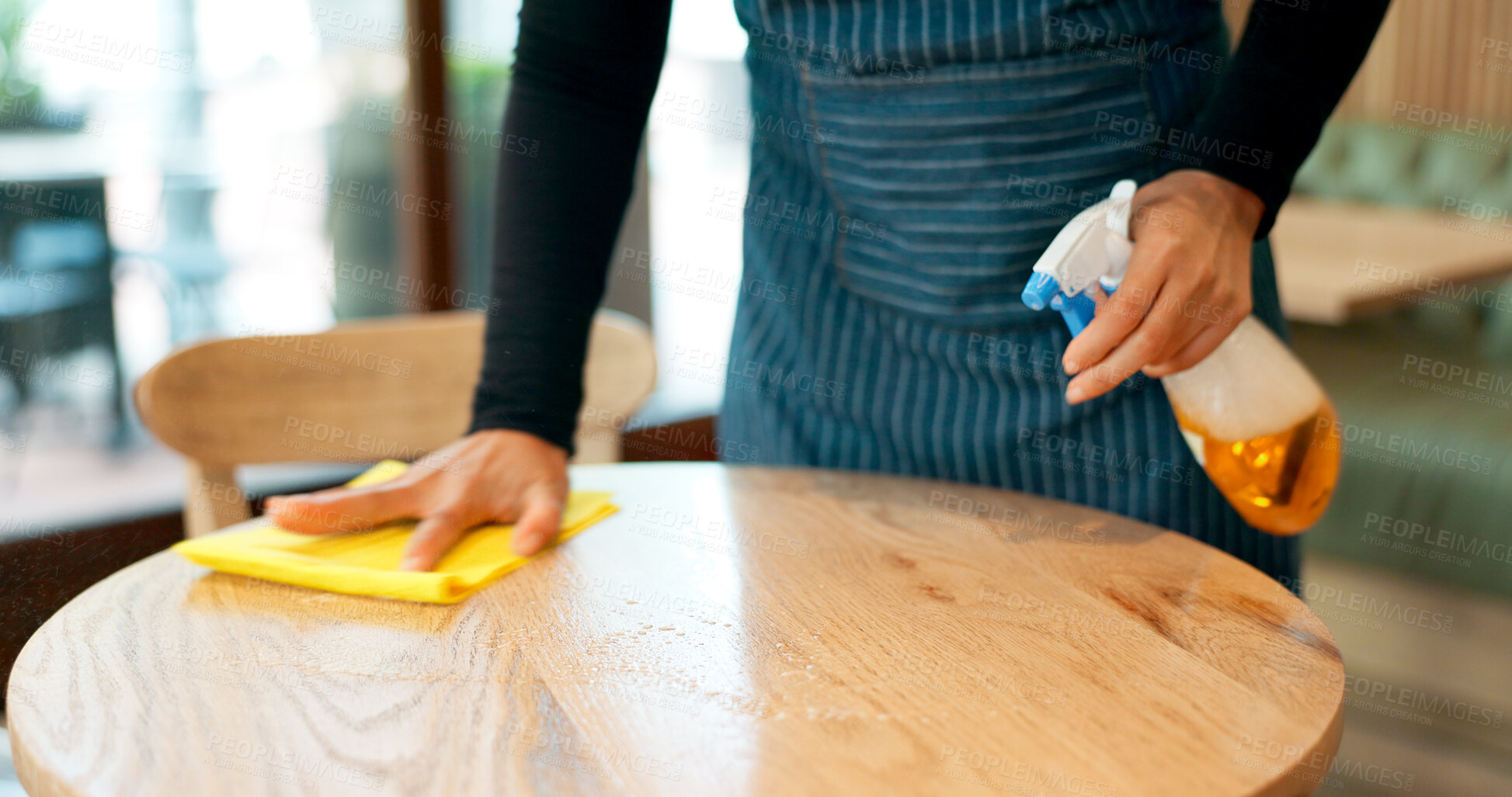 Buy stock photo Waiter, hands and cleaning table in cafe for dust, bacteria and dirt with cloth, spray or detergent. Barista, person and wipe wooden furniture in coffee shop or restaurant with chemical liquid