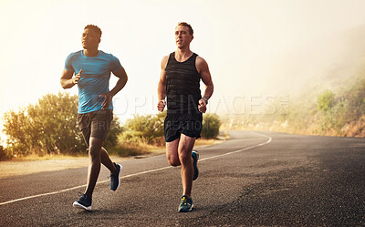Buy stock photo Shot of two sporty young men out for a run together