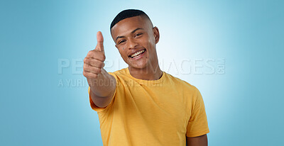 Buy stock photo Thumbs up, portrait and man in studio for agreement, winning deal and celebrate achievement on blue background. Happy model, emoji and like sign for yes feedback, success and thank you for excellence