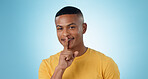 Man, portrait and finger on lips for quiet sign, secret deal or smile in studio for promotion by blue background. Person, hand and cover mouth for icon, emoji or gossip for stop voice, news or drama