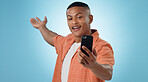 Live streaming, video call and influencer man on blue background for social media, online post and internet. Selfie, showing and person with smartphone for mobile app, recording and blog in studio