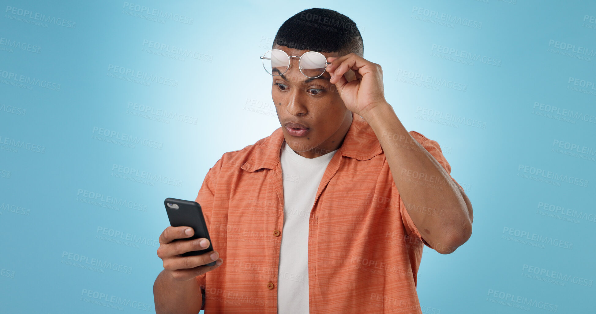 Buy stock photo Man, cellphone and shock texting gossip or social media search, internet rumor or surprise communication. Male person, mobile and glasses for secret message, blue studio background as mockup space