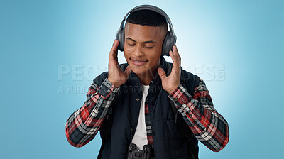 Buy stock photo Happy, man and headphones in studio for music, podcast and relax with audio subscription on blue background. Smile, freedom and young model listening to sound, streaming multimedia and hearing radio 
