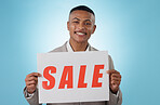 Portrait, sale sign or businessman by offer, discount deal or launch for logo advertising in studio. Happy, smile or manager with board for message, marketing or promotion card on blue background