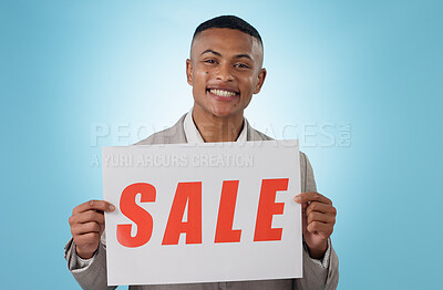 Buy stock photo Portrait, sale sign or businessman by offer, discount deal or launch for poster advertising in studio. Happy, smile or manager with board for message, marketing or promotion card on blue background