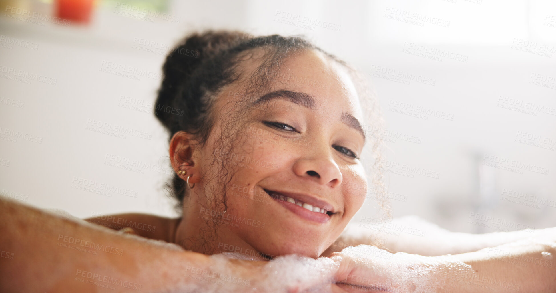 Buy stock photo Happy, peace and face of a woman in a bath at her home for calm, relaxing and self care routine. Smile, headshot and portrait of young female person from Mexico with mindfulness in a tub in bathroom.
