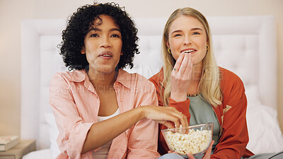 Television, happy and women friends on a bed with popcorn for movie, comedy or standup show at home. Comic, snack and ladies watching tv in a bedroom laugh, bond and relax with streaming subscription