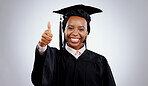 Graduation cap, thumbs up and woman or student success with celebration, education and learning or college achievement in studio. Portrait of an african graduate with like emoji on a white background