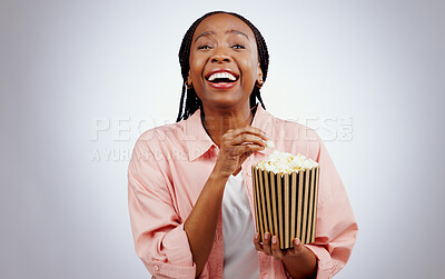 Portrait, laughing or black woman watching a movie in studio for cinema with popcorn to relax. Comedy, funny or happy African person eating snack for streaming film or subscription on grey background
