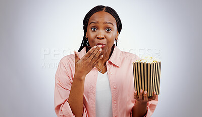 Portrait, surprise or black woman watching movie in studio for cinema with popcorn to relax. Omg, wow or shocked African person eating snack for streaming film or subscription on grey background