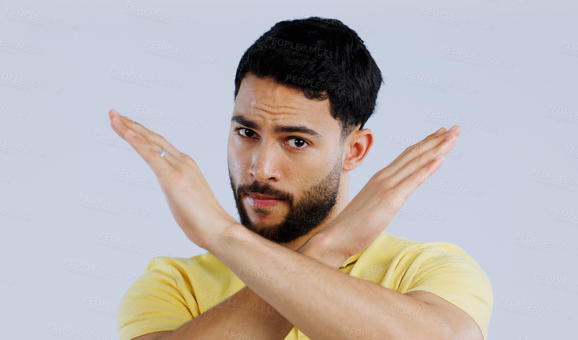 Buy stock photo Portrait, man and cross sign for stop, no and protest for rejection, ban and wrong emoji in studio on white background. Indian model warning of caution, cancel decision and objection to vote