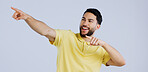 Man, pointing and offer in studio with hands to promotion, announcement or excited for deal in gray background. Banner, space or person show choice, decision and gesture to information or opportunity