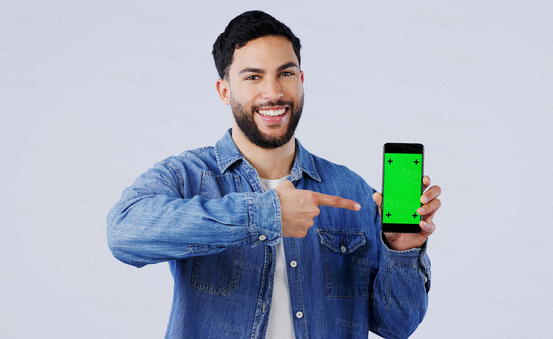 Buy stock photo Man, smartphone or pointing to green screen in portrait, mockup space or happy for advertising. Arab person, smile or face in marketing of tracking markers, mobile app or contact by white background