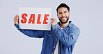 Happy man, portrait and sale sign for discount, promotion or banner against a gray studio background. Male person or model smile with billboard or poster for advertising or marketing store promo